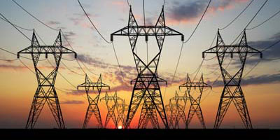 série de lignes à haute tension sur fond de soleil couchant
